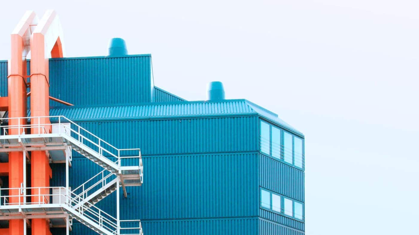 fachada de fábrica, mostrando chaminés, tubulações e escadas externas